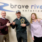 TOP DESIGNERS: Brave River Solutions Inc. President Jim McAssey, left, and Director of Client Services Rebecca Arsenault celebrate their recently earned website design award for Outstanding Achievement in Web Development in the Best Photography Website category from the Web Marketing Association’s annual Web Awards competition with KingBirder.com founder and CEO Tom Younkin. / COURTESY BRAVE RIVER SOLUTIONS INC.