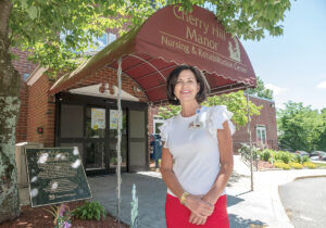 AT HOME: Kathleen Gerber stands outside the Cherry Hill Manor Nursing & Rehabilitation Center in Johnston, where she is executive director.  PBN PHOTO/MICHAEL SALERNO