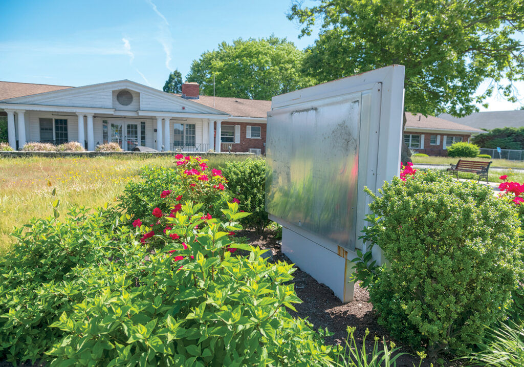 WHAT REMAINS: The sign has been removed and the lawn is uncut outside the former Elderwood at Riverside nursing home in East Providence. The 57-bed facility closed at the end of May, the fifth nursing home in Rhode Island to shutter since the COVID-19 pandemic began.  PBN PHOTO/MICHAEL SALERNO