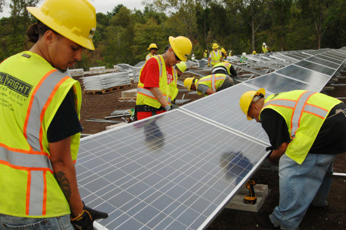 SHINING EXAMPLE: Workers install solar panels at East Providence Forbes Street project, due for completion in 2017. / PBN FILE PHOTO/BRIAN MCDONALD