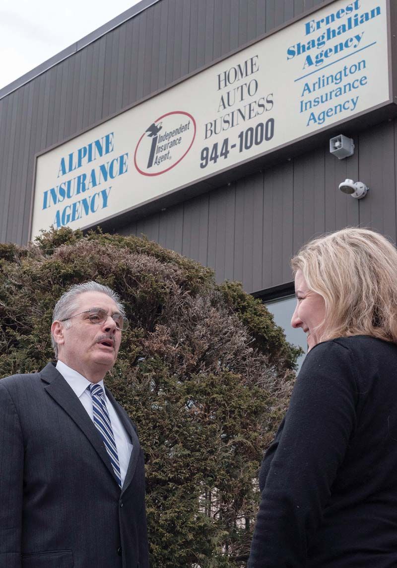 CONCERNED AGENT: Ernest Shaghalian Jr., owner of Alpine Insurance Agency in Cranston, talks with Mary-Margaret Trigo, client-services representative. Shaghalian is concerned owners aren’t currently covered by insurance when their cars are used for ride-hailing purposes in Rhode Island. / PBN PHOTO/MICHAEL SALERNO