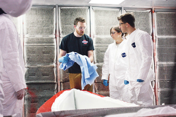 IYRS SCHOOL OF Technology and Trades student Andrew Leonard, black T-shirt, shows Massachusetts Institute of Technology students Carrie McKnelly and Tyler Crain how to prepare a mold for a lightweight canoe. The IYRS campus in Bristol is one example of the East Bay's concentration of composites expertise, which a new $125,000 federal grant from the U.S. Economic Development Administration aims to tap into. /COURTESY MICHAEL CAMERON IYRS SCHOOL OF Technology and Trades student Andrew Leonard, black T-shirt, shows Massachusetts Institute of Technology students Carrie McKnelly and Tyler Crain how to prepare a mold for a lightweight canoe. The IYRS campus in Bristol is one example of the East Bay's concentration of composites expertise, which a new $125,000 federal grant from the U.S. Economic Development Administration aims to tap into. /COURTESY MICHAEL CAMERON