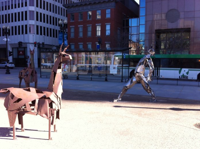 Two six-foot llamas and a man made of car bumpers are among the scrap art sculptures installed in Kennedy Plaza./PBN PHOTO/ MARY MACDONALD TWO 6-FOOT LLAMAS and a man made of car bumpers are among the scrap art sculptures installed in Kennedy Plaza in Providence. / PBN PHOTO/ MARY MACDONALD