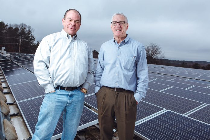 GREEN TEAM: National Marker CEO Michael Black, left, and General Manager Patrick Madigan show off the company’s solar array outside its North Smithfield facility. / PBN PHOTO/RUPERT WHITELEY