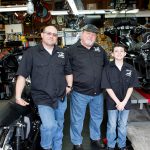 HAVING FUN: James “Big Jim” Annis, right, and James “Jimmy” Annis, left, with Robert James Annis, at East Bay Custom Cycles in Bristol, a motorcycle customize and repair shop, which Big Jim and Jimmy opened together last May. / PBN PHOTO/KATE WHITNEY LUCEY