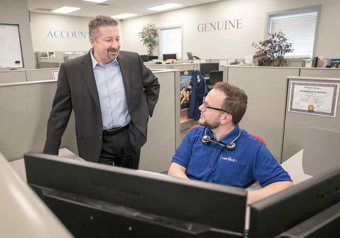RECRUITING KEY: CEO Rick Norberg, left, speaks with Teddy Kennedy, service desk apprentice, at Vertikal 6 in Warwick. Norberg said the company’s full-time apprenticeships have become the key to recruiting and developing employees.
 / PBN PHOTO/MICHAEL SALERNO RECRUITING KEY: CEO Rick Norberg, left, speaks with Teddy Kennedy, service desk apprentice, at Vertikal 6 in Warwick. Norberg said the company’s full-time apprenticeships have become the key to recruiting and developing employees.
 / PBN PHOTO/MICHAEL SALERNO