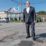 PROACTIVE APPROACH: ­Warwick Mayor Joseph J. Solomon stands on New England Way at the intersection of Gilbane Street. Both roads are on the schedule to be repaved. Solomon said roadwork has been a priority since he took office in spring 2018. He says last year was the first time in 20 years the city has implemented a proactive program.  / PBN PHOTO/MICHAEL SALERNO
