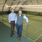 COURTING MEMBERS: Lance Pryor, left, owner and member of Agawam Hunt’s management team, and Joshua Helm, assistant general manager and controller, are pictured at the club’s indoor tennis courts. Pryor said golf “as the sole value proposition” is a challenging one right now.  / PBN PHOTO/MIKE SKORSKI