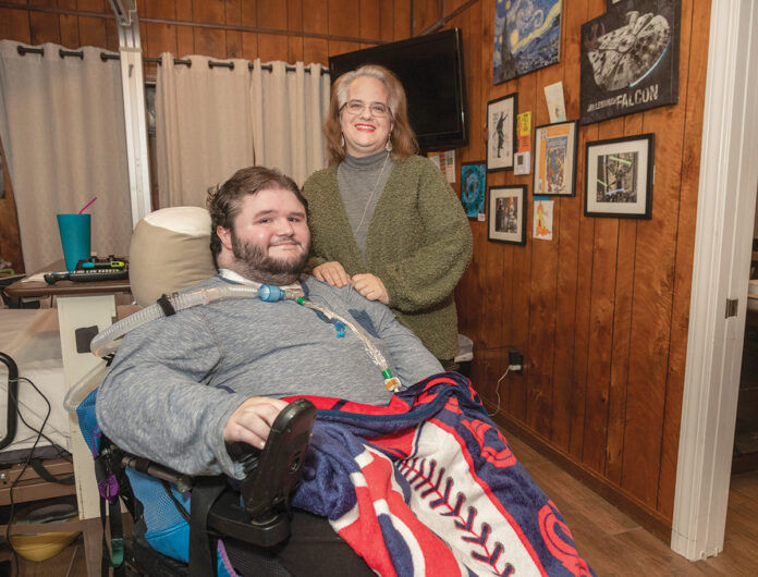 SOME GOOD NEWS: Lee-Ann Quinn’s son, Zach, just turned 21 and his family learned recently that the state will continue to cover the nursing care that he needs to stay at home. About 15 other families are waiting for word on similar benefits for children who’ve recently aged out of pediatric benefits. / PBN PHOTO/MICHAEL SALERNO SOME GOOD NEWS: Lee-Ann Quinn’s son, Zach, just turned 21 and his family learned recently that the state will continue to cover the nursing care that he needs to stay at home. About 15 other families are waiting for word on similar benefits for children who’ve recently aged out of pediatric benefits. / PBN PHOTO/MICHAEL SALERNO