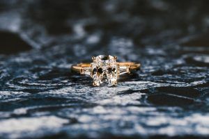 Main Keyword how much should you spend on an engagement ring - image of old mine brilliant cut elongated cushion lab grown diamond engagement ring with baguette side stones on abstract blue black white background