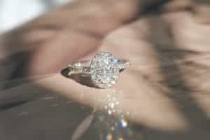 White gold, oval cut engagement ring with natural round diamonds in a halo