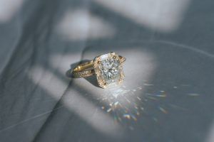 art deco engagement rings - vintage aethetic yellow gold engagement ring featuring a moissanite radiant centre and baguette halo