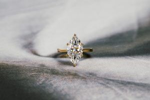 how much should you spend on your engagemen ring: lab grown diamond marquise engagement ring, abstract gray background