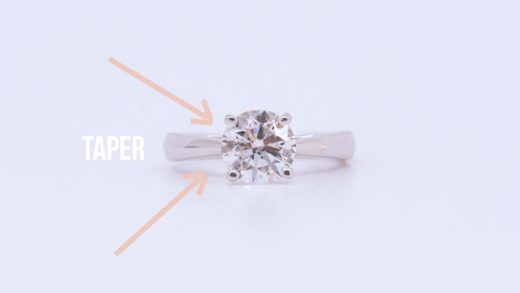 Top down view of diamond ring with illustration indicating tapering of ring band