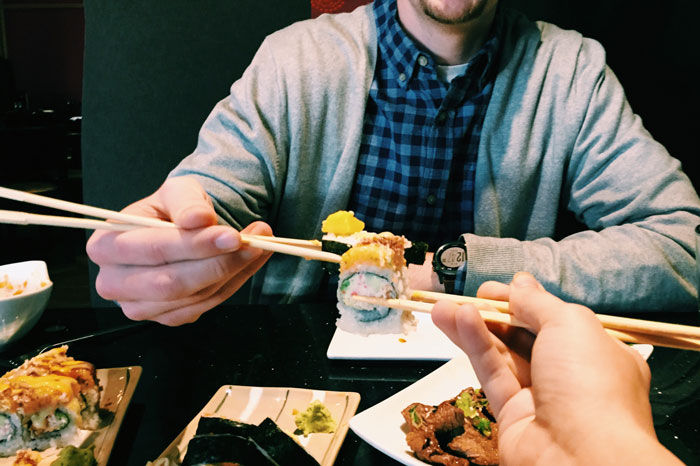 Mann holder en maki med spisepinner