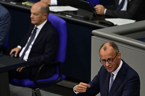 Leader of Germany's Christian Democratic Union (CDU) party Friedrich Merz gestures as he addresses the plenary session while German Chancellor Olaf Scholz is seen sitting the the background in the Bundestag, Germany's lower house of parliament, in Berlin on September 11, 2024. (Photo by John MACDOUGALL / AFP)