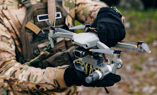 Armeesoldaten halten Luftaufnahmen - Drohne mit Bombe für den Flug zu feindlichen Stellungen im Militäreinsatz.