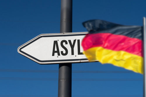 Deutsche Flagge / Flagge Deutschland mit Schild im Hintergrund Asyl