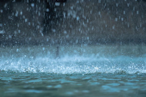 Starke Regentropfen, die auf den Boden spritzen / Regen / Starkregen