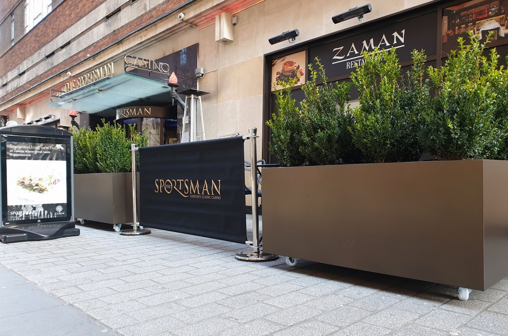 Large moveable metal planters on lockable castors for a restaurant frontage