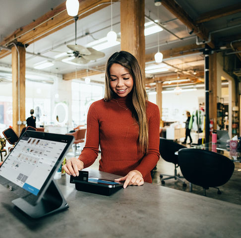 Woman paying by card in shop