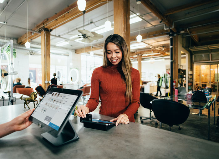 Woman paying by card in shop