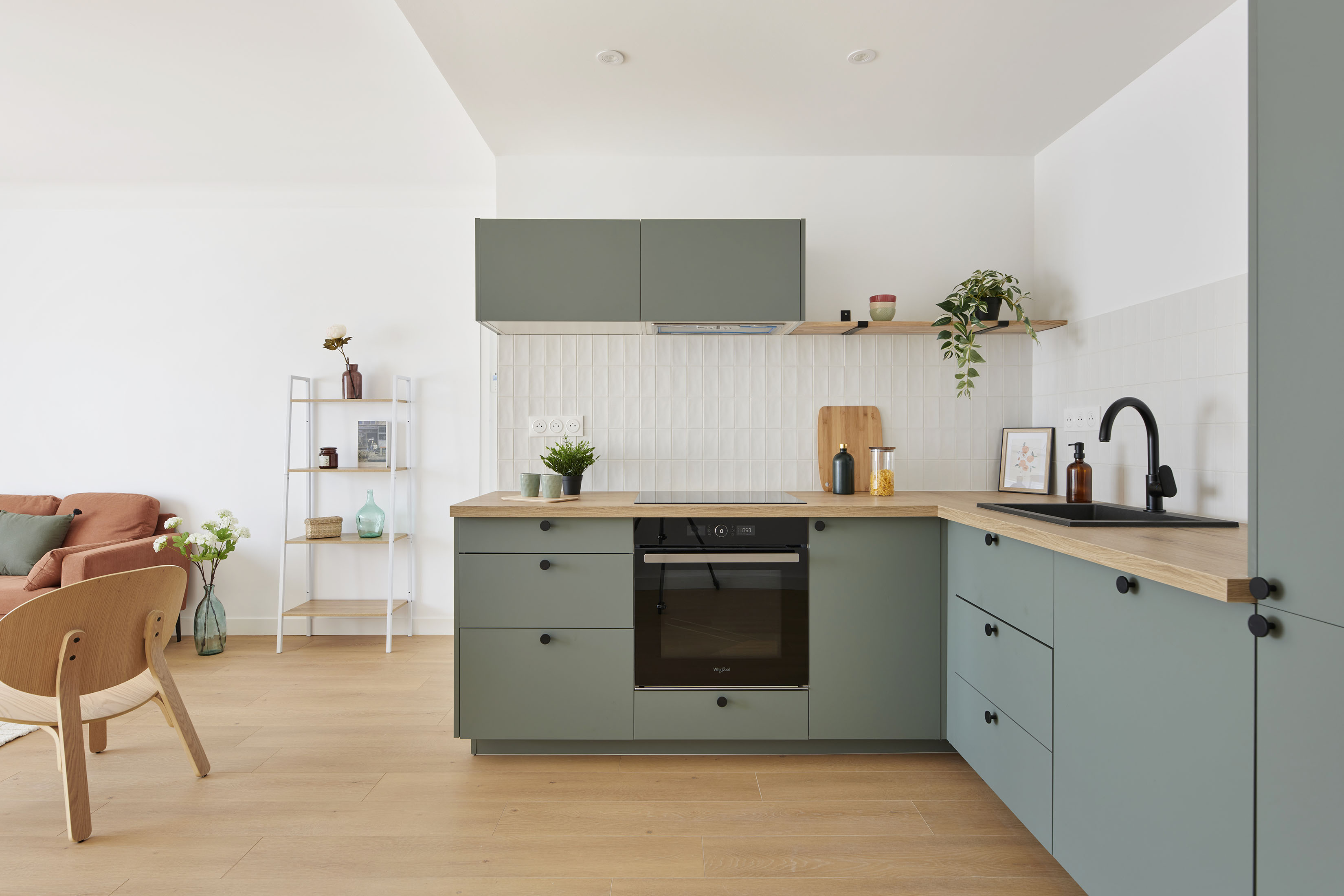 meubles de cuisine vert sauge avec accessoires de décoration (plante, vaisselle, planche, bocaux...) dans appartement à nantes