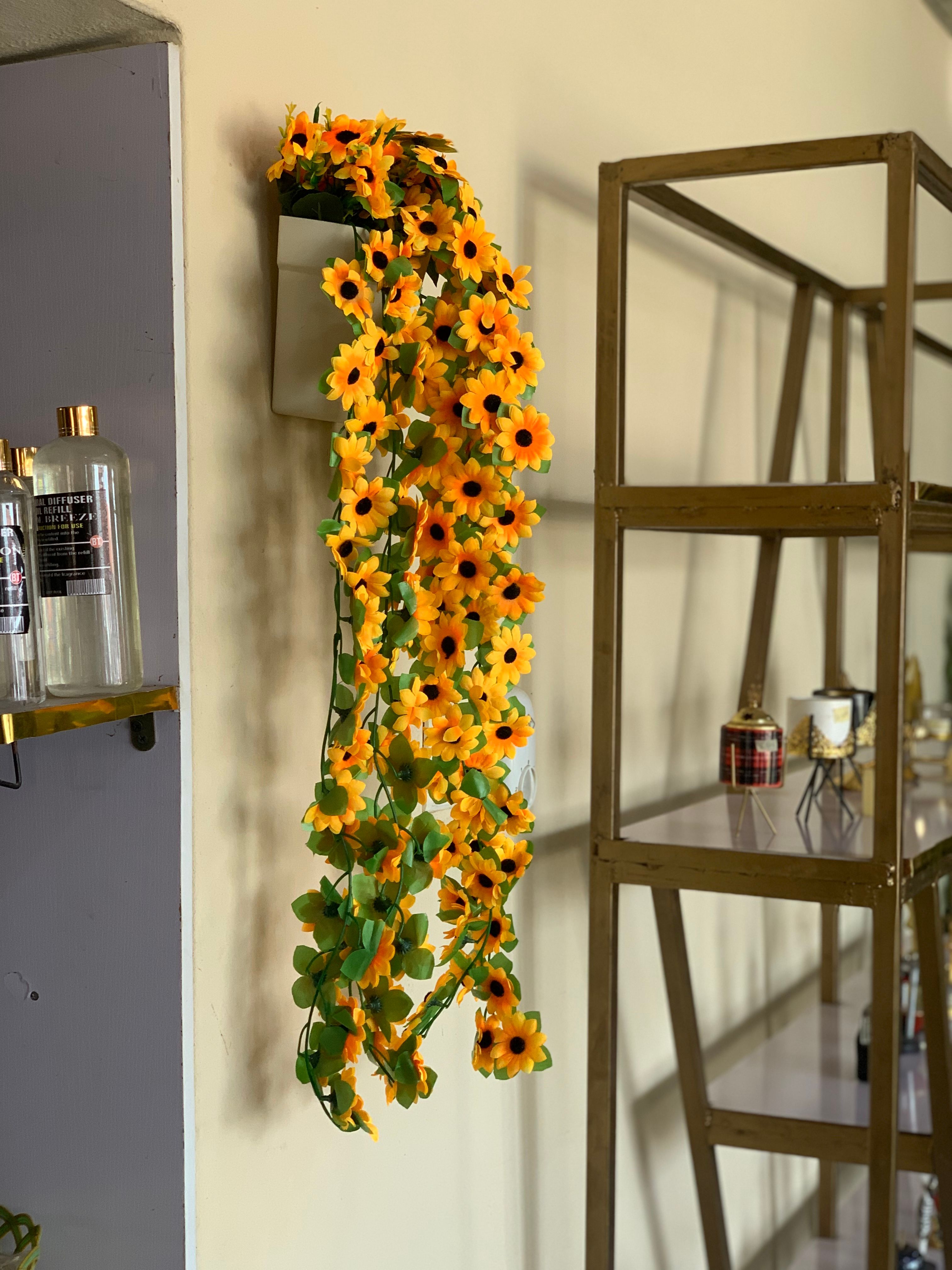 Dropping sunflowers in plastic wall vase Image