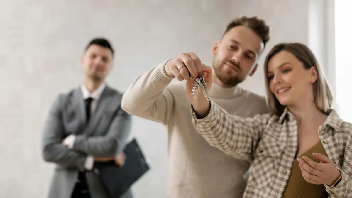 Casal segurando chaves da casa após contemplação no consórcio caixa