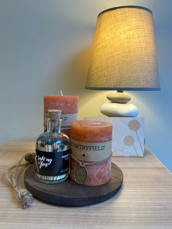 -	Rond, zwart houten plankje				
-	Grote en kleine kaars (oranje)				
-	Lucifers							
-	Houten kaartje voor een persoonlijke boodschap
