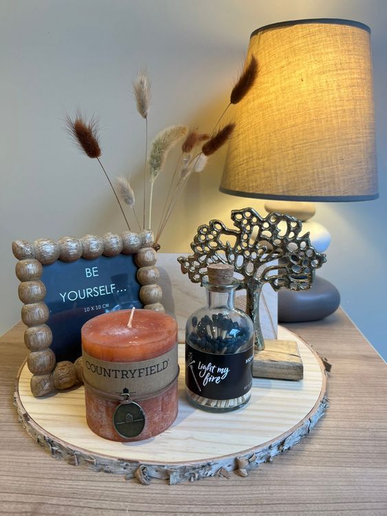 -	Boomstronk plankje						
-	Vaasje met droogbloemetjes					
-	Staander met gouden levensboompje				
-	Kadertje met foto						
-	Kaars (oranje)							
-	Lucifers						
-	Staander met een houten kaartje voor een persoonlijke boodschap	

