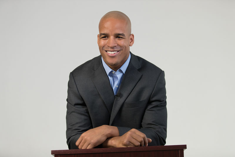 Male presenter wearing lavalier mic at lectern