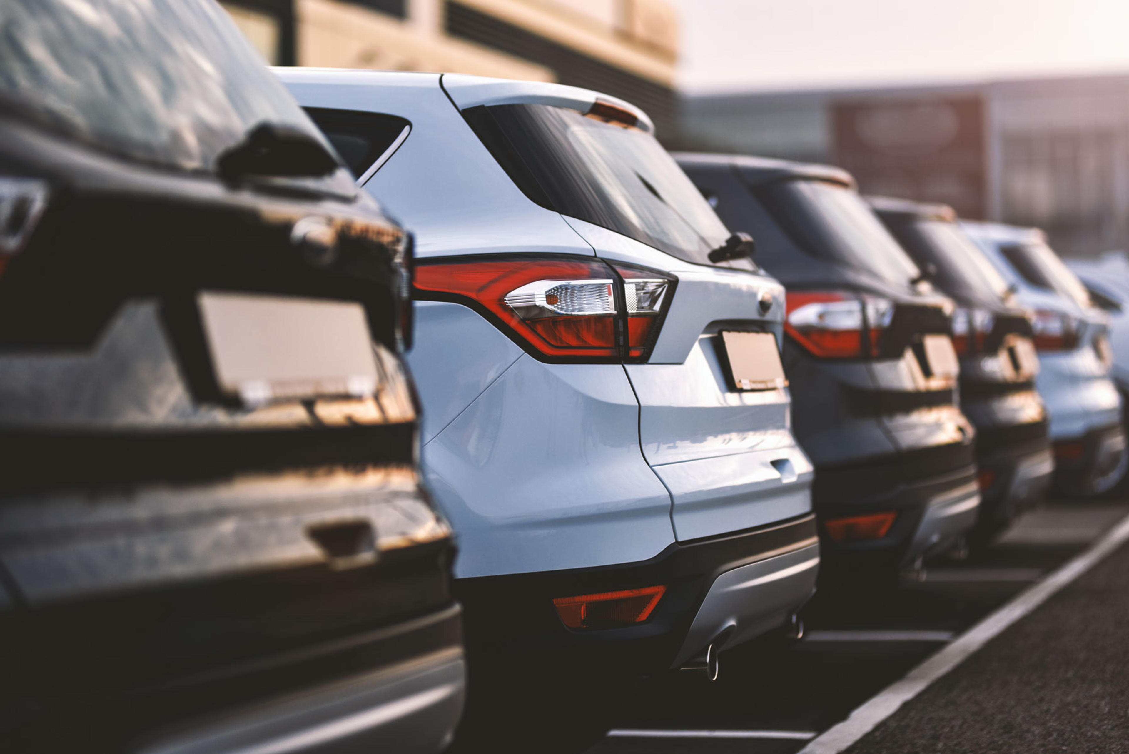 Cars parked in row on outdoor parking