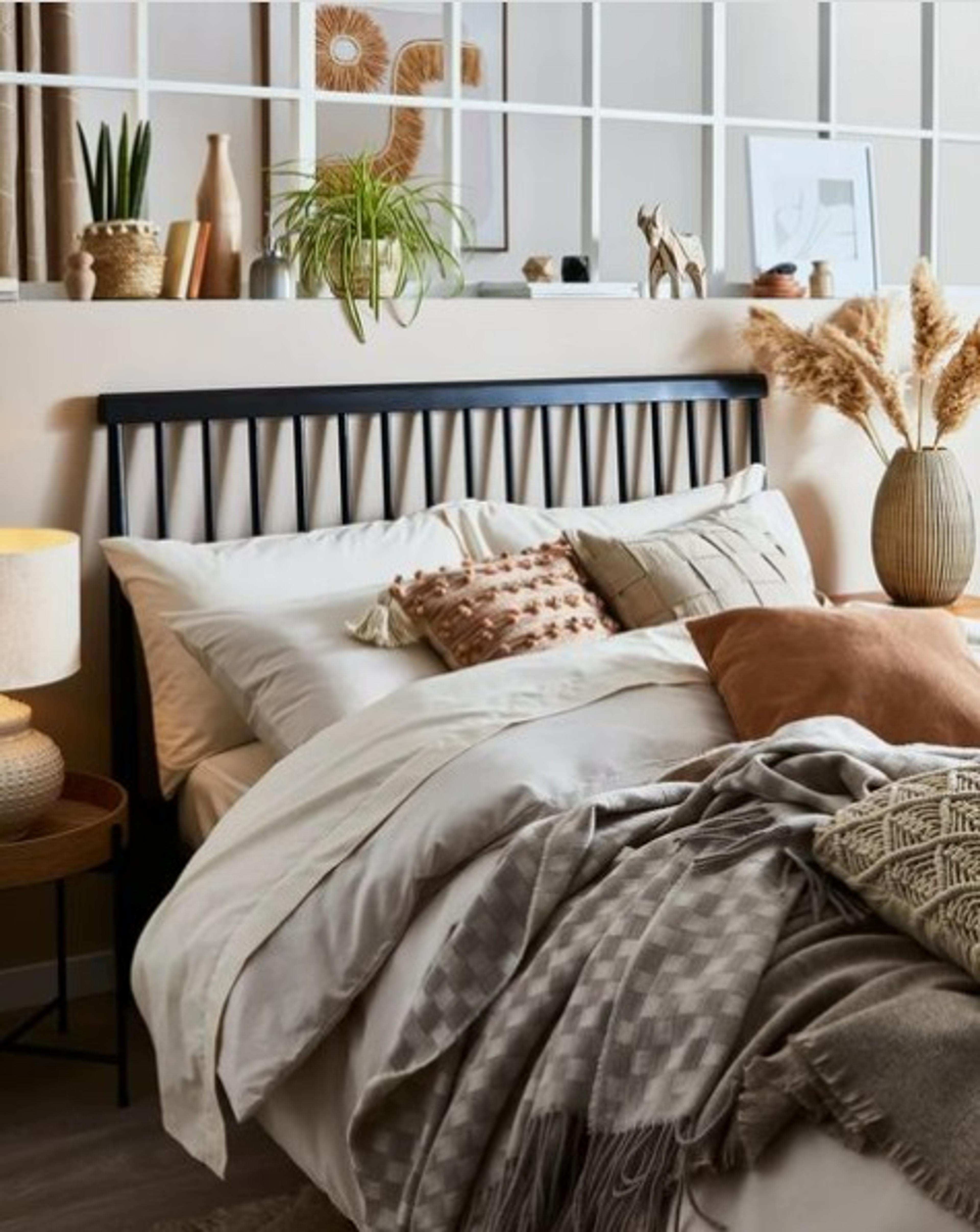 A full bed piled with comfy pillows and blankets