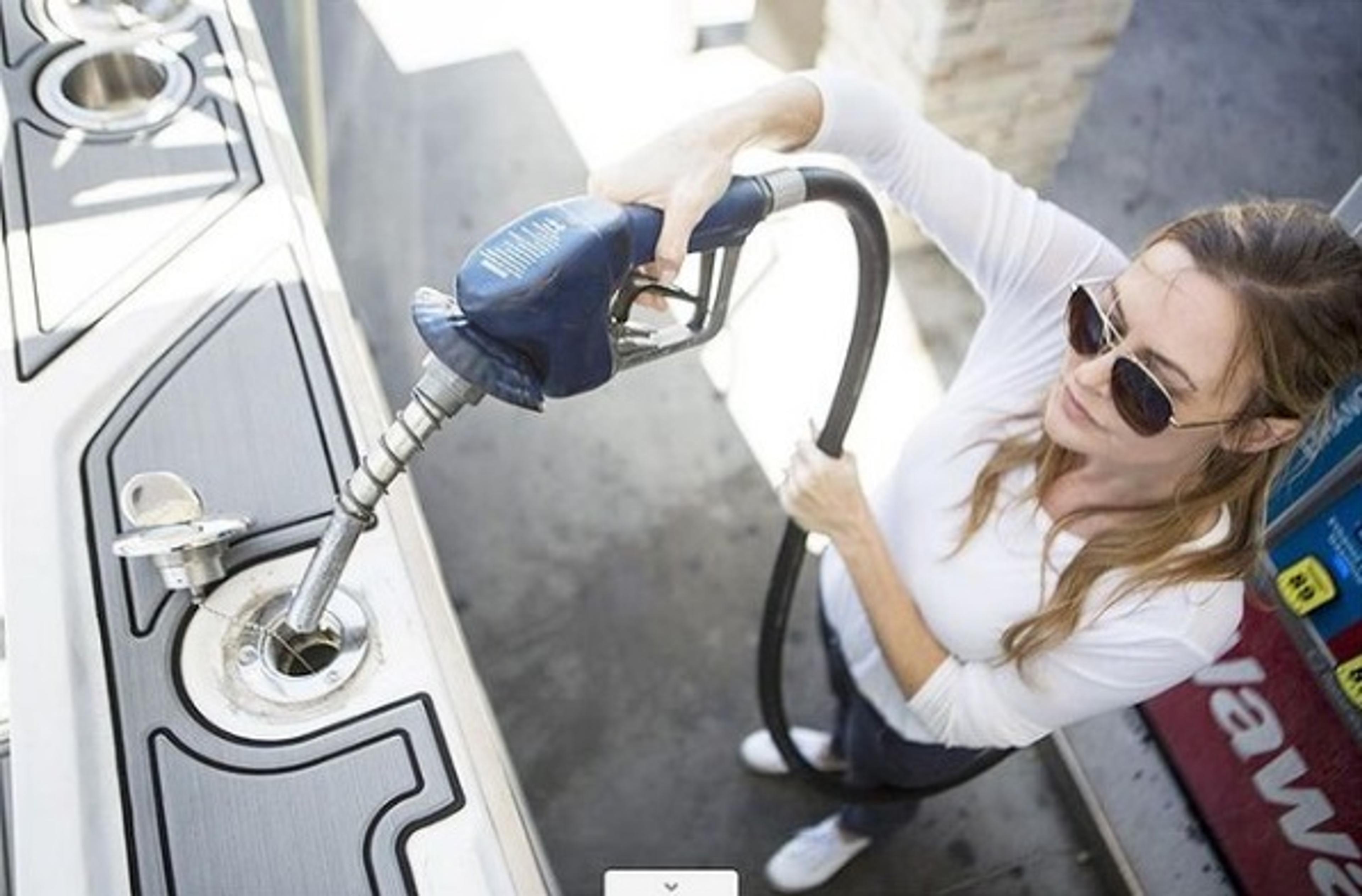 Woman at a gas pump filling up a boat