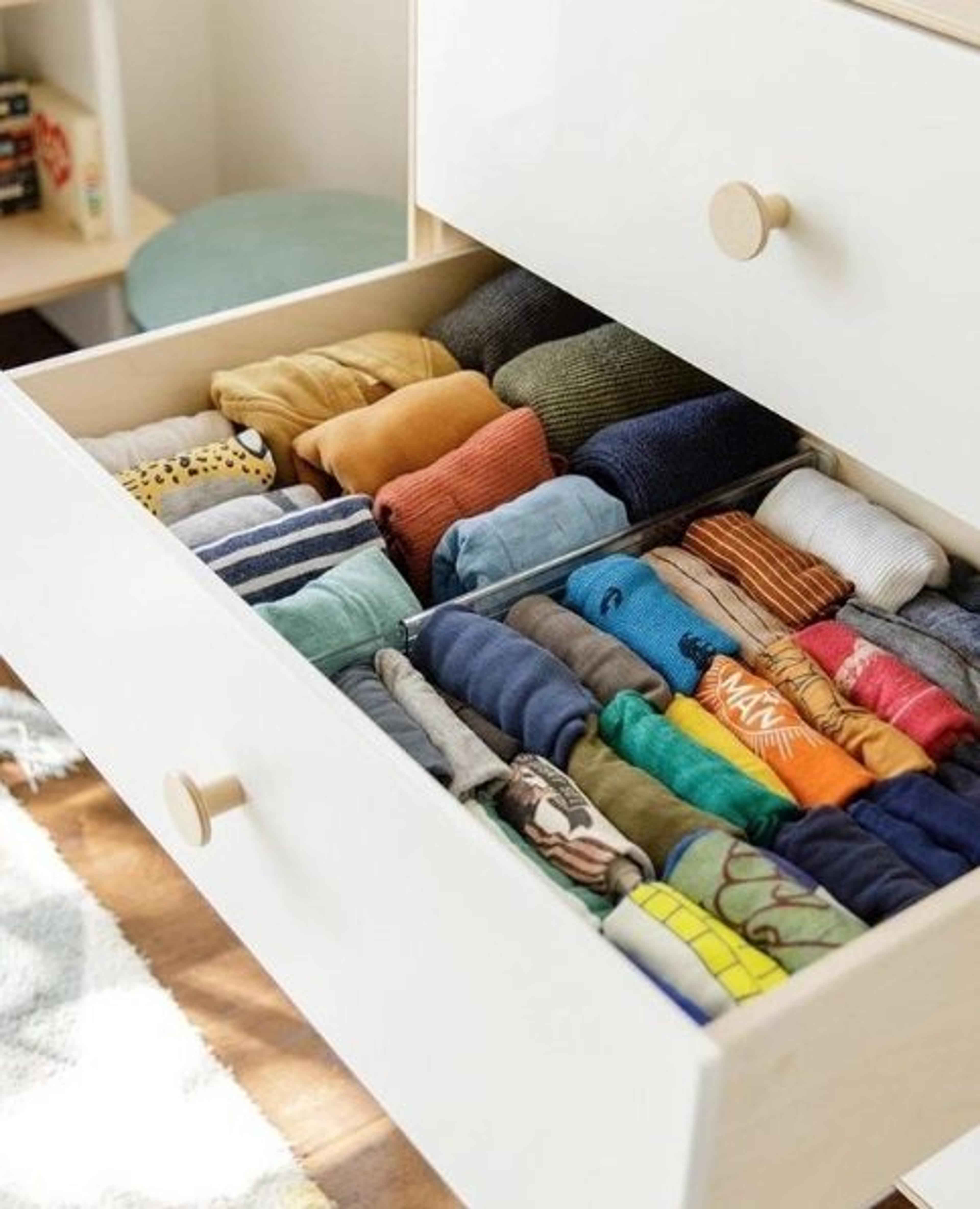 Image of an open drawer with shirts folded vertically