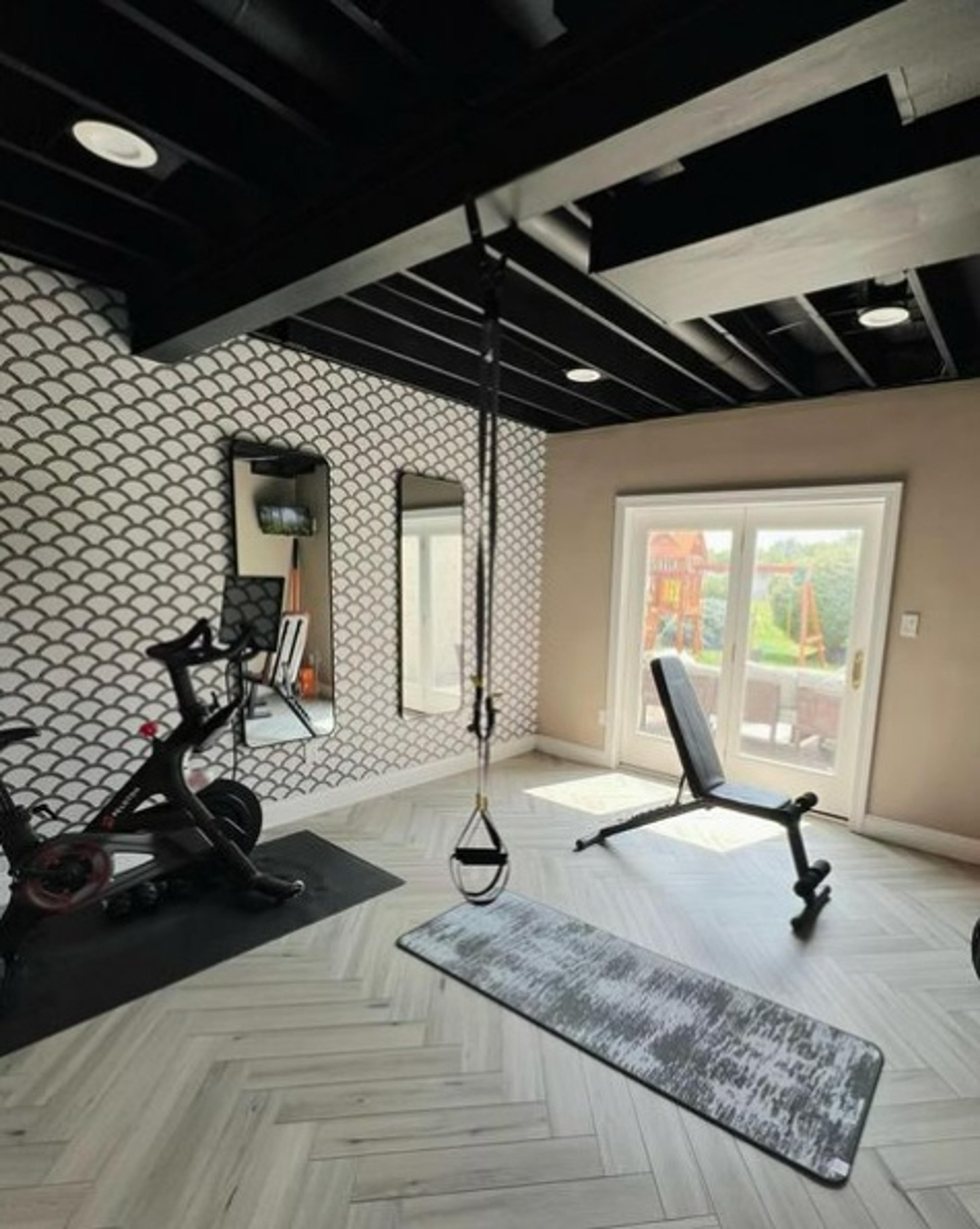 Home gym with a fun patterned wallpaper accent wall.
