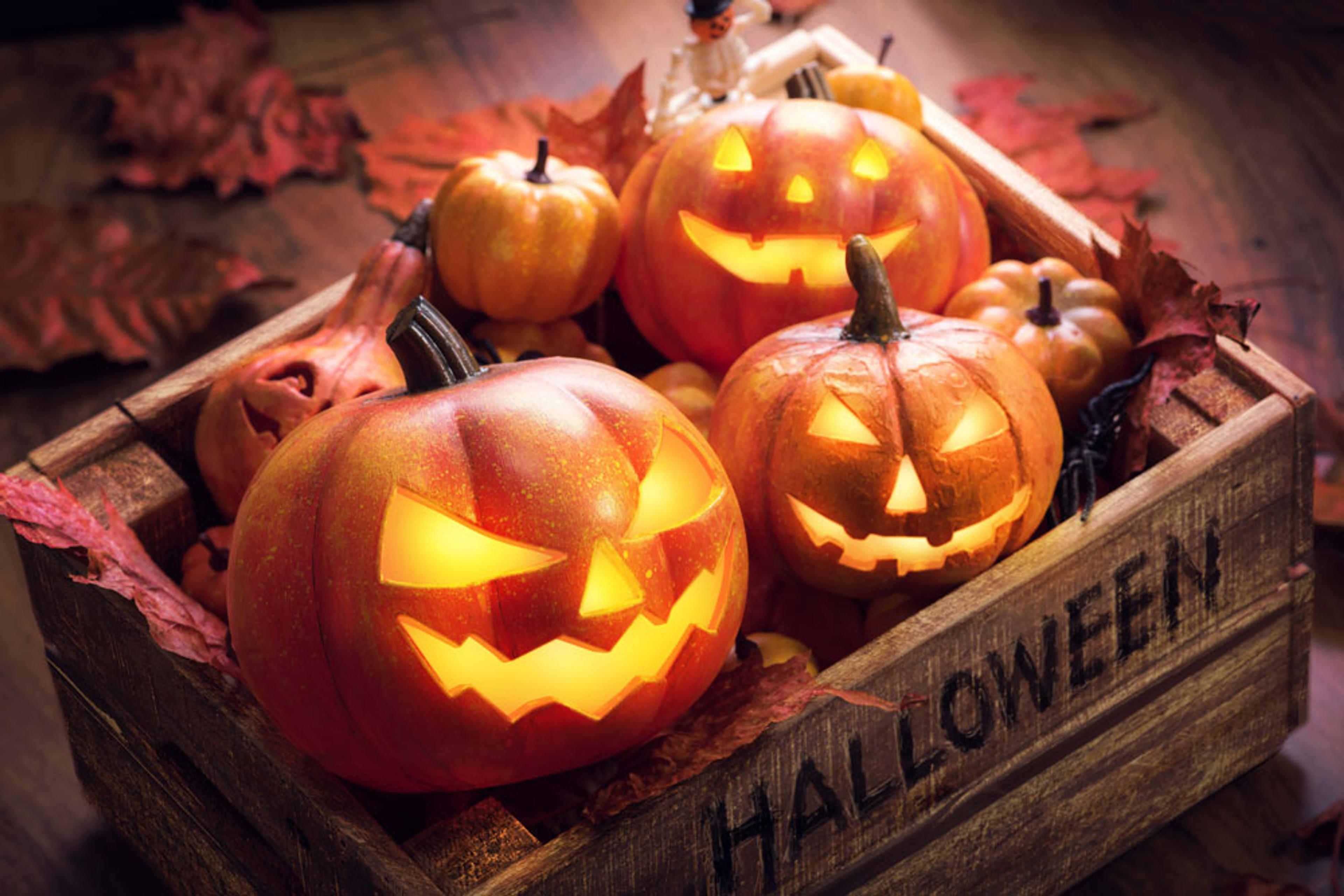 Jack-o-lantern and pumpkin decorations placed in a wooden box