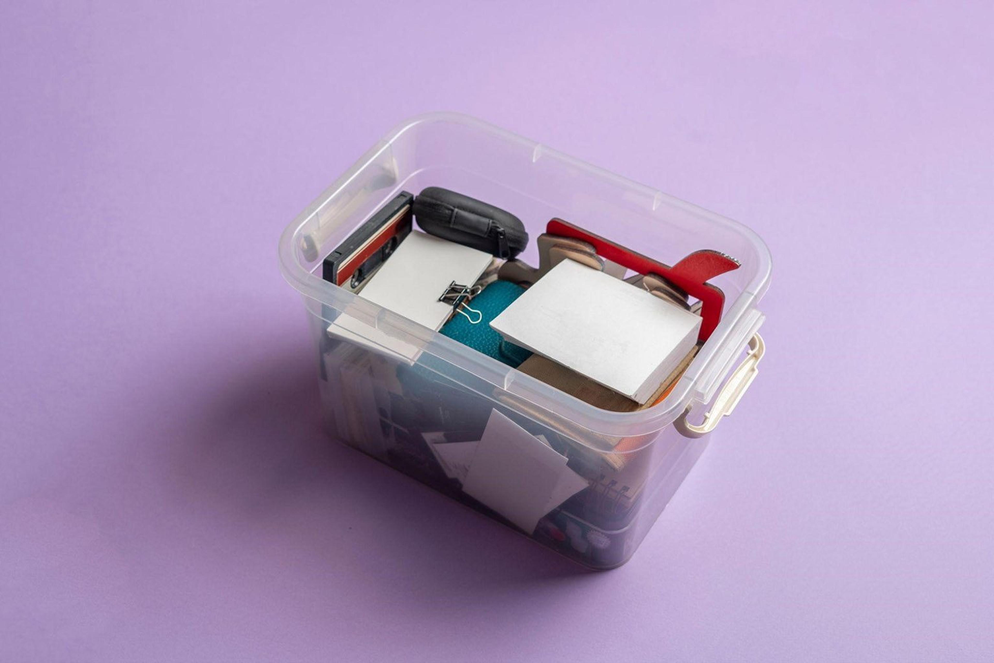 A plastic storage box in front of a lavender background.