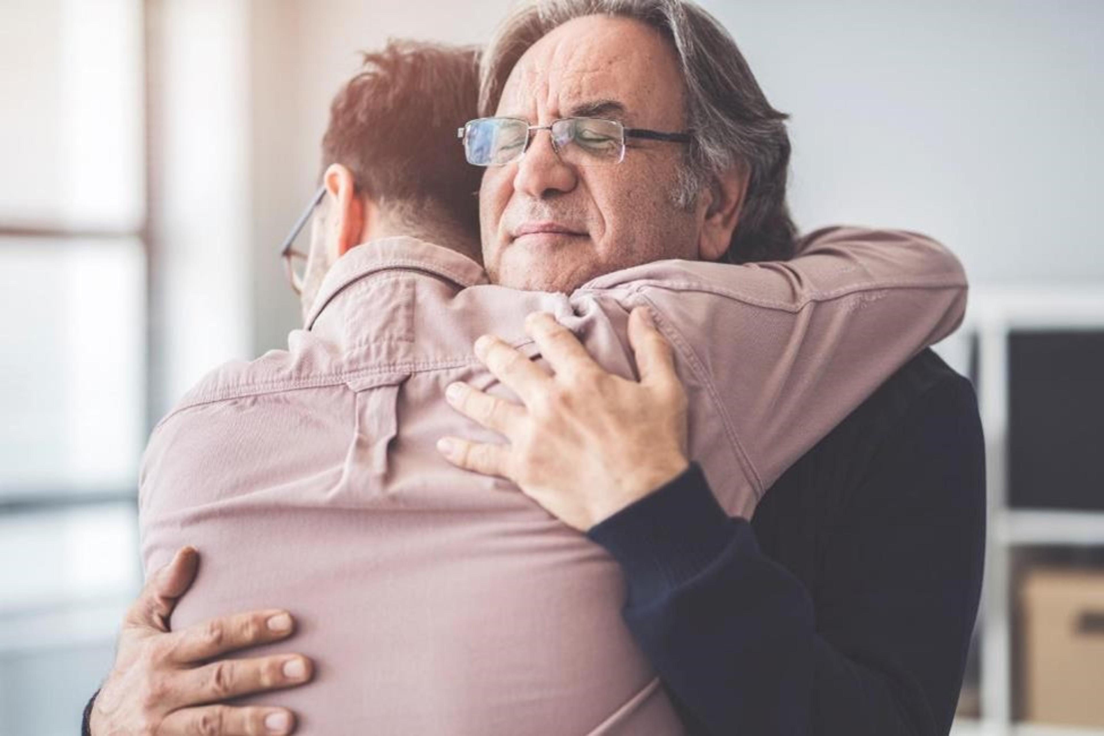 A father and a son hugging each other.