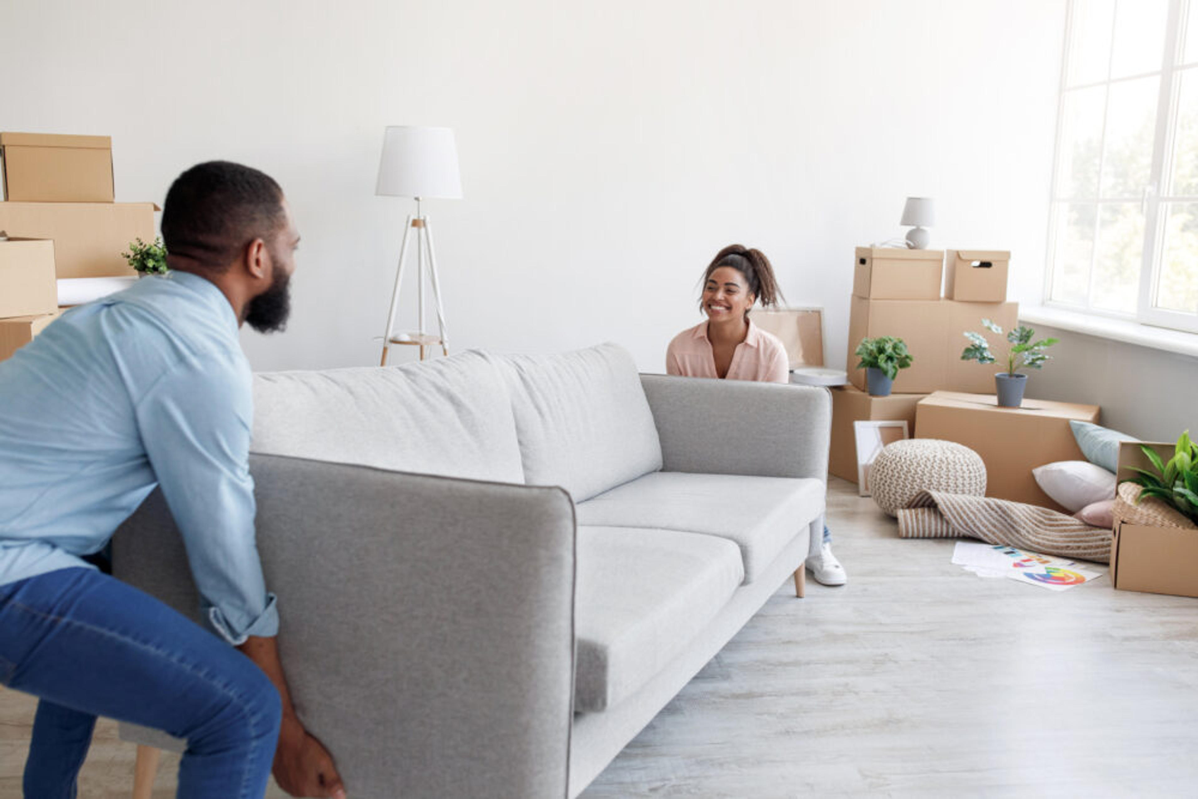 Two young homeowners moving their couch