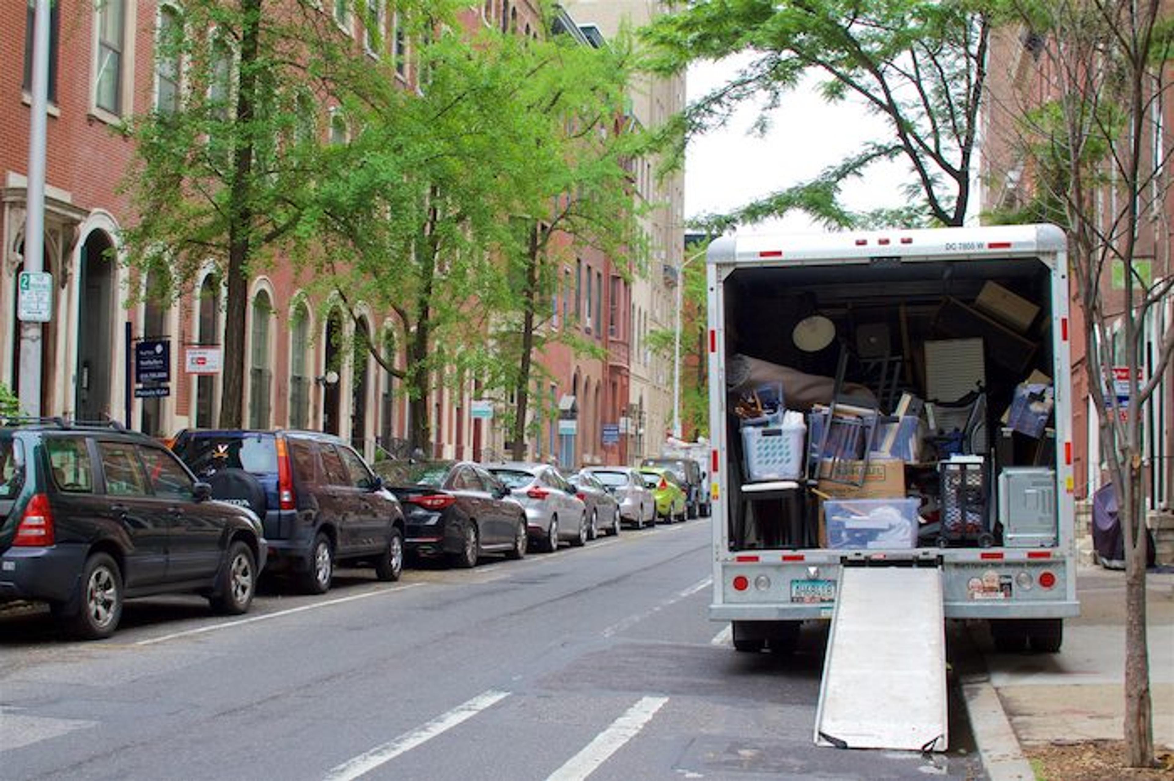 a moving truck with its ramp down, contents already loaded inside.