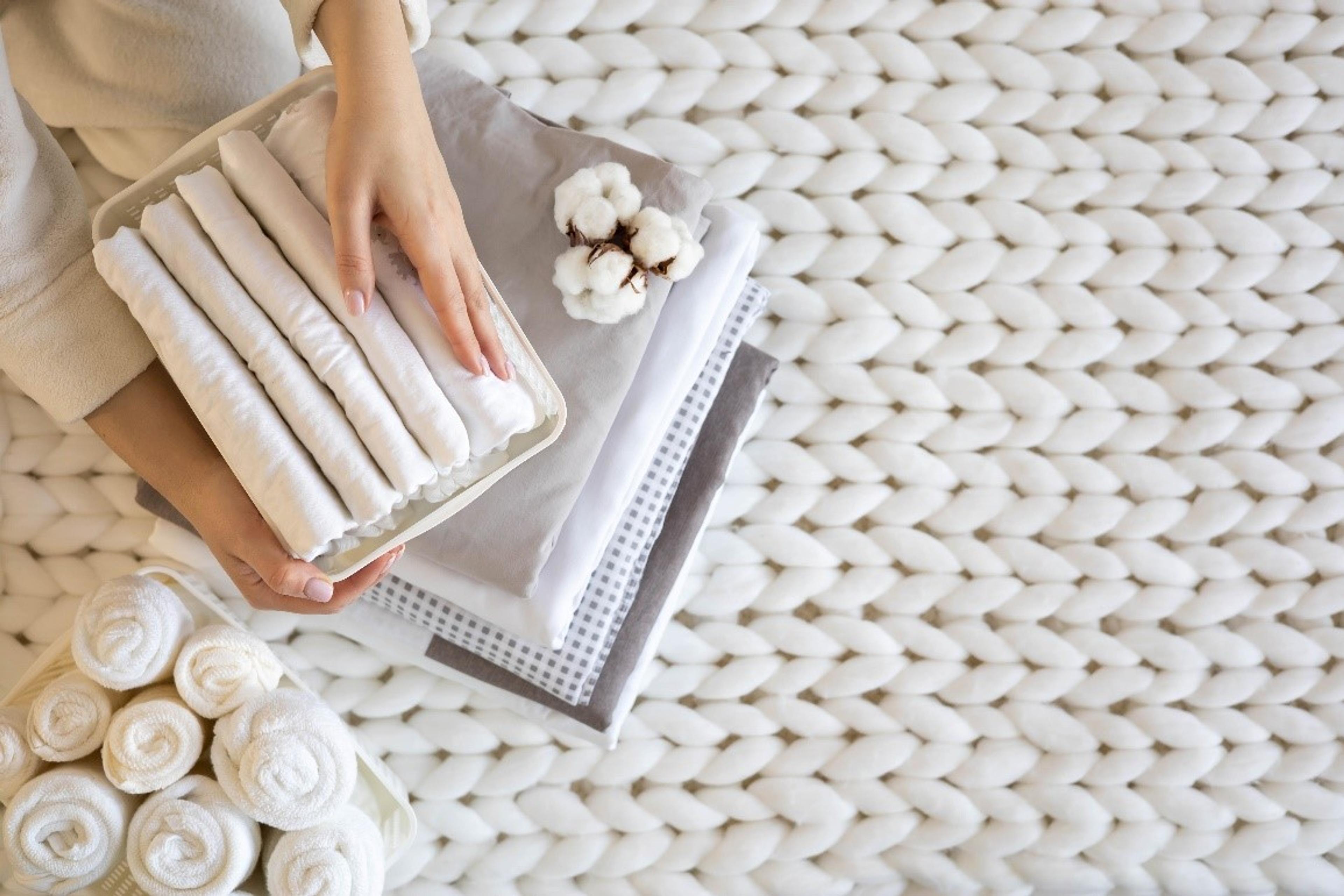 Woman with a stack of white folded towels
