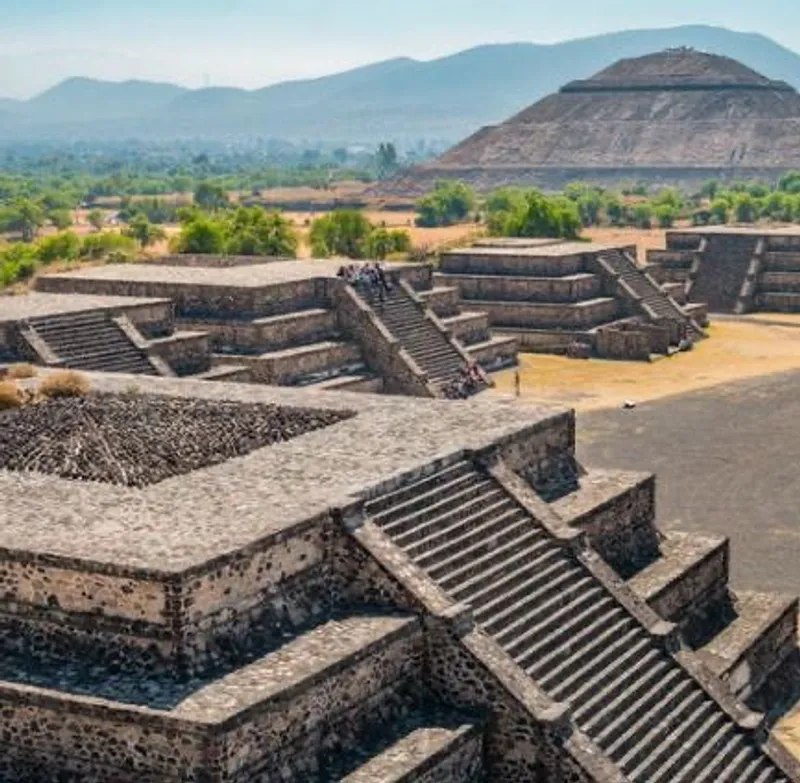 Ancient stone pyramid at Teotihuacán with a wide staircase, surrounded by a courtyard