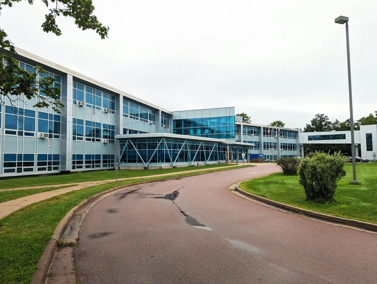 A school campus building with a curved access road and landscaped lawn