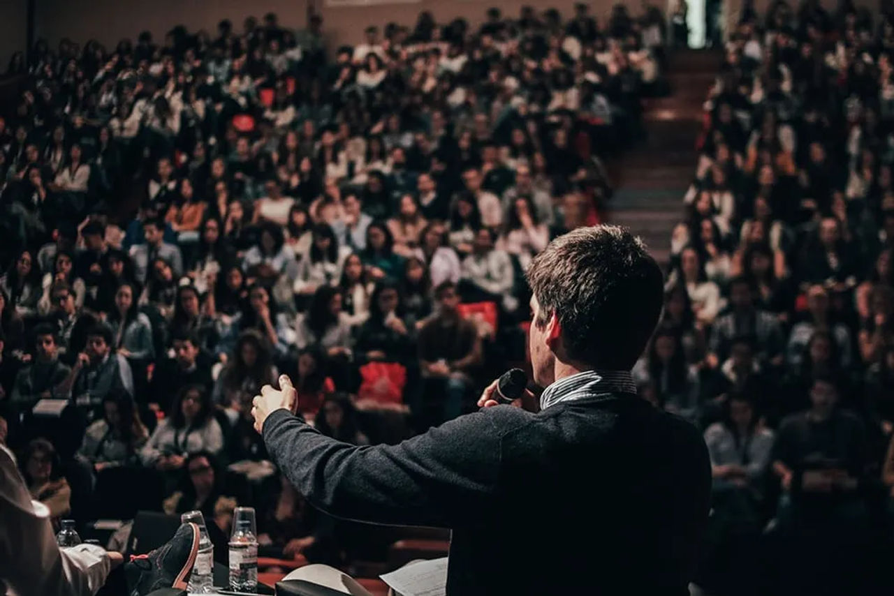 Speaker presenting to an audience in a lecture hall
