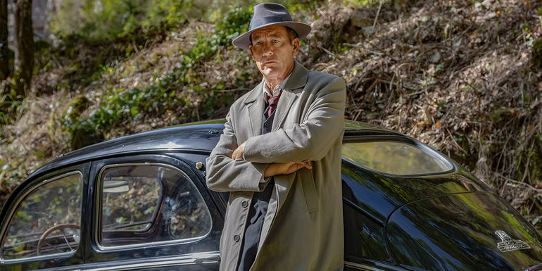 Clive Owen as Sam Spade leaning against car in Monsieur Spade