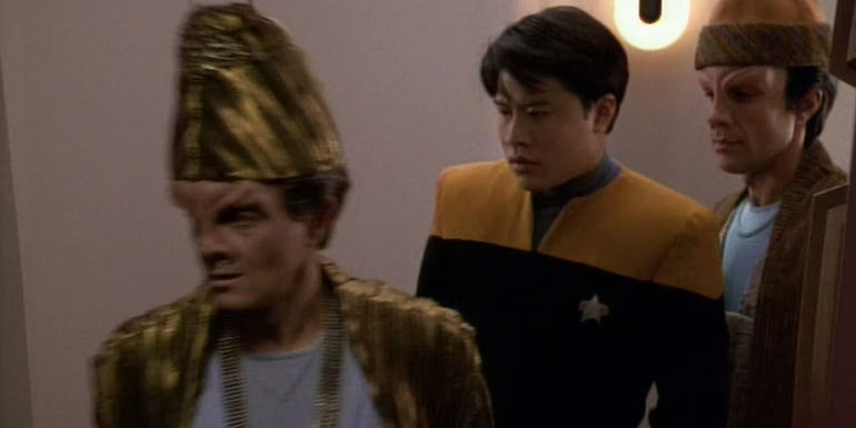 harry kim is probably in trouble standing between two alien men wearing robes and cool hats in voyager emantions