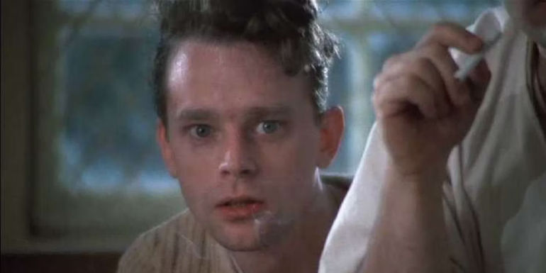 Brad Dourif as Billy Bibbit against a window