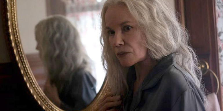 Judith Albright (Barbara Hershey) near a reflection of herself in the mirror in The Manor